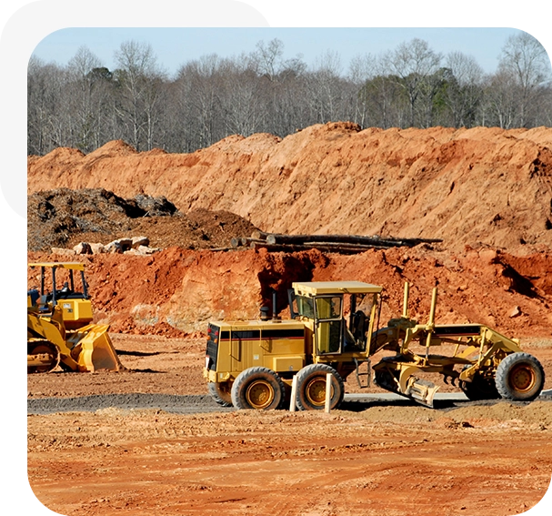 A large dump truck parked on top of a dirt field.